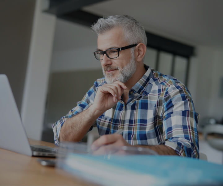 man with glasses staring at computer